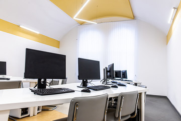 office room with computer tables with keyboard and mouse with a board and a projector