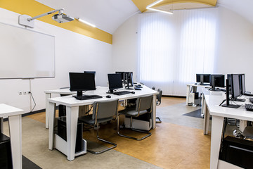 office room with computer tables with keyboard and mouse with a board and a projector
