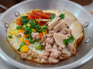 Menu egg pan with ingredients of fried egg, pork and vegetables. 
Breakfast of Southern Thailand.