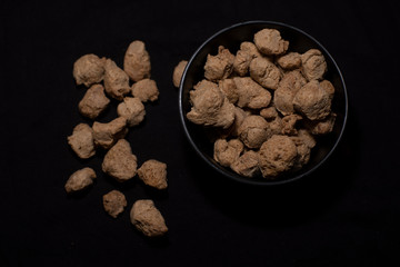 A bowl of soya chunk in a dark copy space background. Food and product photography.