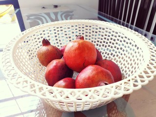 Pomegranate fruits in white basket.