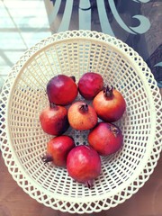 Pomegranate fruits in white basket.