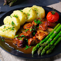 dumplings with beef goulash and green asparagus