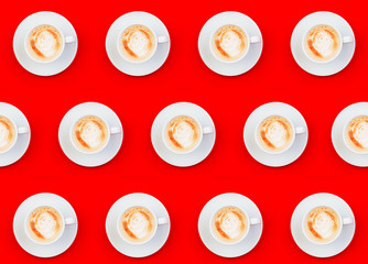 Cup with latte pattern on red color background, flat lay top view