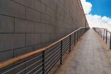 A wheelchair ramp, an inclined plane installed in addition to or instead of stairs, Slope walkway for disabled people, people pushing strollers, carts with stainless bars to prevent falling