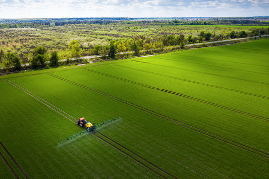 Farmland in Europe, tractor spraying pesticides