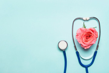 Stethoscope and beautiful rose heart on blue background. Thank you doctor and nurse day concept