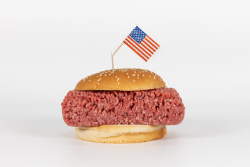 Hamburger mit rohem Hackfleisch und beschädigter USA Flagge
