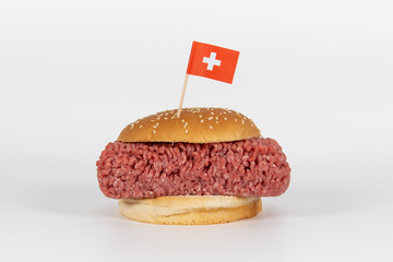 Großer Hamburger mit rohem Hackfleisch und  schweizer Flagge