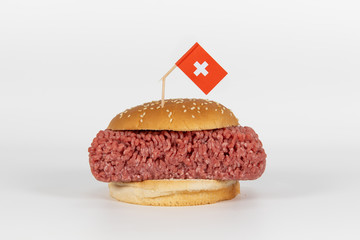 Großer Hamburger mit rohem Hackfleisch und chweizer Flagge