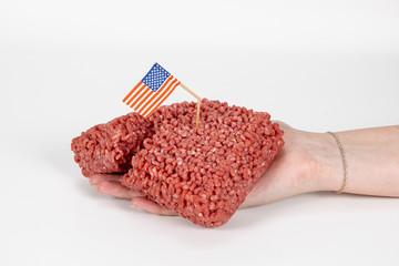 Weibliche Hand hält rohes Hackfleisch mit beschädigter USA Flagge