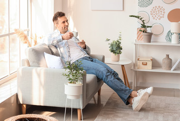 Obraz na płótnie Canvas Handsome man drinking coffee at home