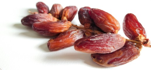 Dried date palm Is a fruit that is naturally sweet Placed on a white surface Natural light