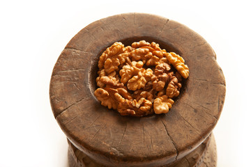 Walnuts in antique, wooden mortar.