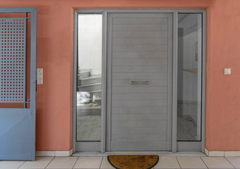 contemporary apartment entrance metallic grey door and pink wall, Athens Greece