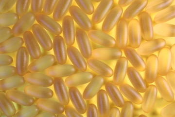 Omega 3 pills. Yellow background with pillows