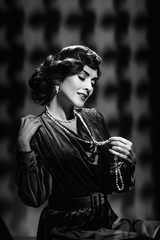 Happy romantic woman wearing vintage necklace and earrings, black and white photo
