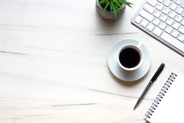White desk office with laptop, smartphone and other work supplies with cup of coffee. Top view with...