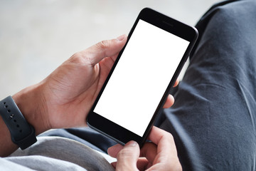 Cropped shot view of man hands holding smart phone with blank copy space screen for your text message or information content, female reading text message on cell telephone during in urban setting. 