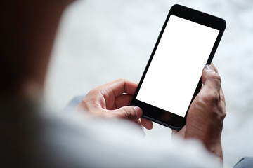 Cropped shot view of man hands holding smart phone with blank copy space screen for your text message or information content, female reading text message on cell telephone during in urban setting. 