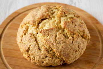 Homemade Irish Soda Bread on a round bamboo board, side view. Close-up.