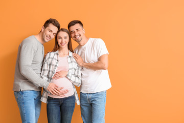 Gay couple with pregnant woman on color background