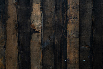 Background of vertical wooden planks with black mud. Wood texture