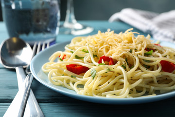 Composition with plate of tasty pasta on wooden background