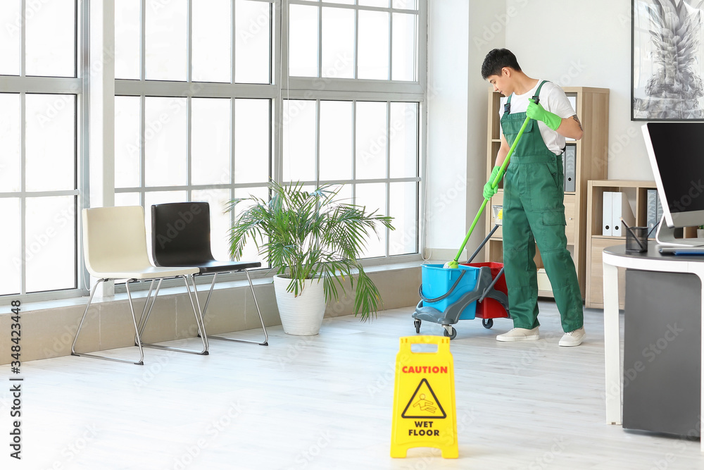 Canvas Prints male janitor mopping floor in office