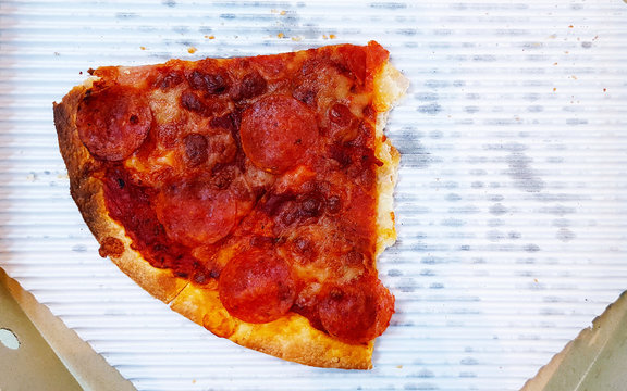 Last Piece Of Pepperoni Pizza On White Paper Tray In Box With Copy Space On Right. Junk, Unhealthy Or Italian Food.  