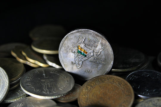 Two rupee coin of India isolated on black background. Map of India as a symbol of the Indian national integration depicted in the Indian coins. Conceptual photography with Indian currency.