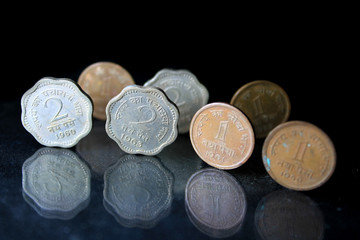 An old Indian one paisa and two paisa coins isolated on a black background. A closeup picture of one naiya paise & Two paise coins. Indian Old vintage coins.