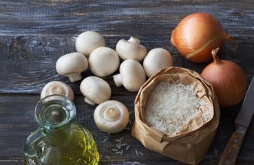 Ingredients for a delicious vegan dish. White basmati rice, garlic and champignons on a wooden table, top view, space, horizontal
