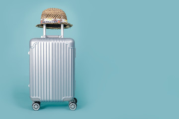 Travel Baggage with hat isolated on blue background with copy space, Travel concept background