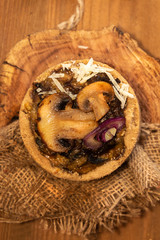 Tarts with mushrooms, caramelized red onion and cheese over on old wooden rustic background.