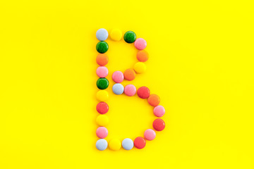 Letter B - alphabet made with sweets on yellow from above