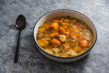 plant-based food, vegan minestrone soup with chunks of carrots potatoes and celeri in vegetable broth