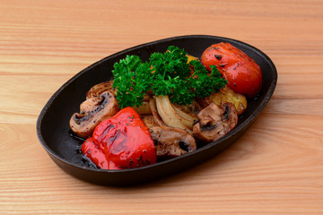 Assorted delicious grilled meat with vegetables. Barbecue, bbq, mushrooms, tomatoes, sweet pepper, fresh raw greenery.