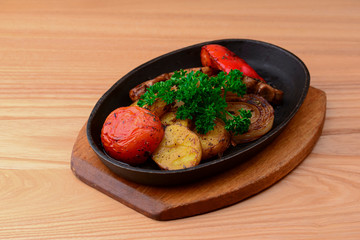 Assorted delicious grilled meat with vegetables. Barbecue, bbq, mushrooms, tomatoes, sweet pepper, fresh raw greenery.