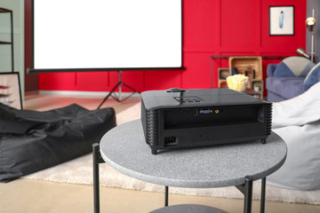 Modern video projector on table in room