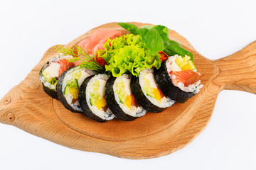 Rolki sushi na drewnianym talerzu w kształcie ryby.