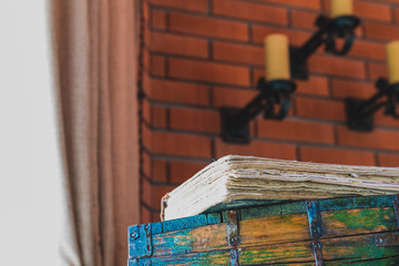 Old book lying on the chest, light from the window