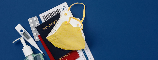 Coronavirus and travel concept. Passports, airplane tickets, sanitizer, thermometer and medical...