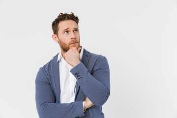 Image of thinking young man wearing jacket posing and looking upward