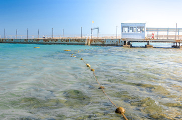 pier leading to the sea on a sunny day/empty pier overlooking the sea on a sunny day