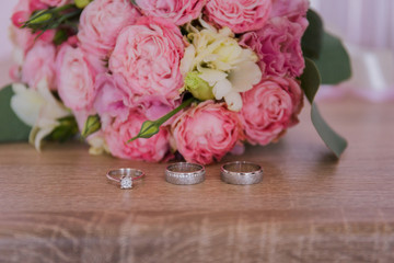 gold rings with a bouquet of the bride on the table