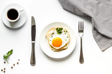 Fried eggs sandwich on plate - white dinner table top view