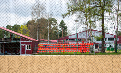 A sports stadium with several rows of spectator seats and a tennis court at a sports stadium or performance venue.