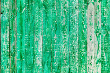 Wooden boards on an old green fence as an abstract background.