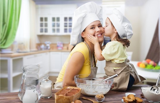 Happy mother and child cooking on kitchen interior